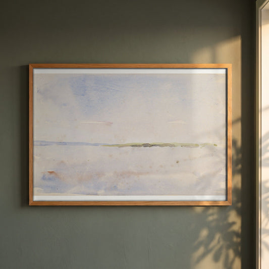 A Distant Coastline framed print in a natural oak frame on a dark green wall beside a window, dappled plant shadow
