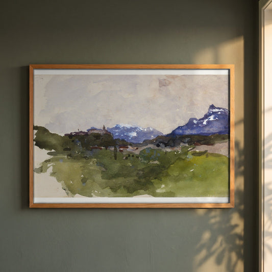 The Pyrenees Mountains framed print in a natural oak frame on a dark green wall beside a window, dappled plant shadow