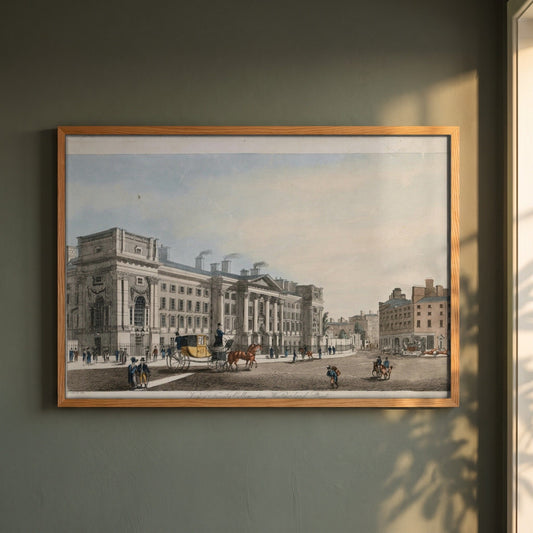 Trinity College Dublin from Westmoreland Street framed print in a natural oak frame on a dark green wall beside a window, dappled plant shadow