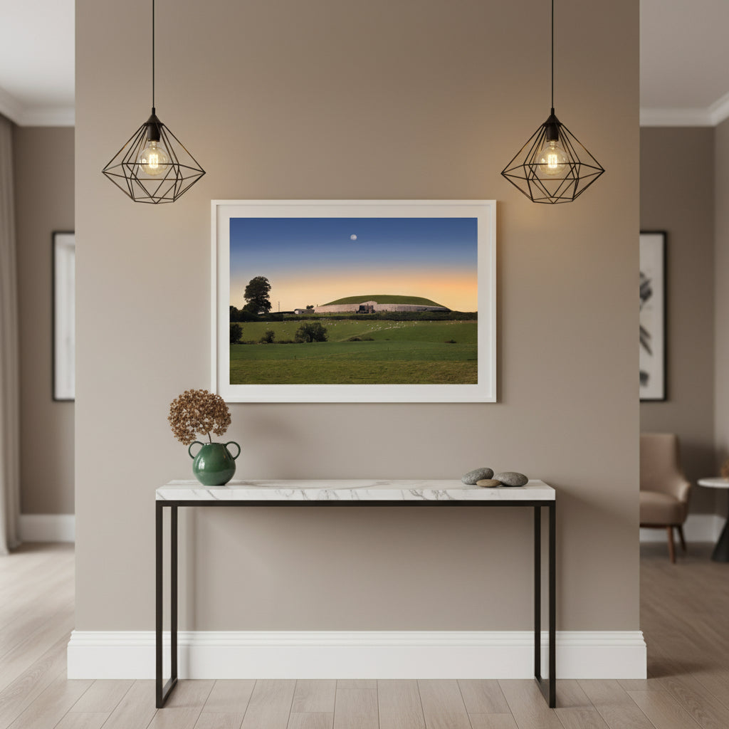 Newgrange Framed Irish landscape print in white frame displayed in a Irish boutique hotel reception area. Marble console below, minimal décor, soft pendant lighting. Contemporary Irish luxury vibe blending culture and design.