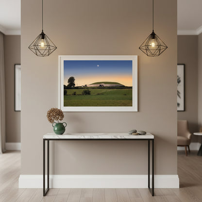 Newgrange Framed Irish landscape print in white frame displayed in a Irish boutique hotel reception area. Marble console below, minimal décor, soft pendant lighting. Contemporary Irish luxury vibe blending culture and design.