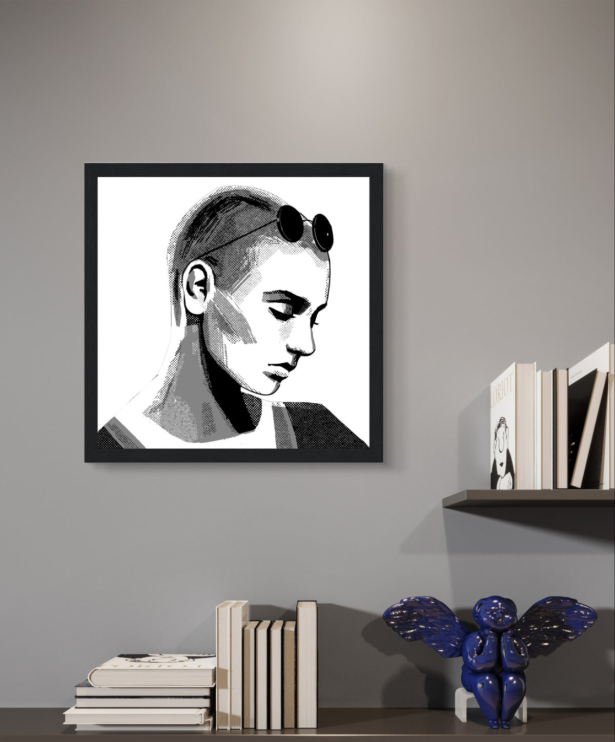 Sinéad O'Connor portrait print in a black frame above wall shelves with books on a grey wall