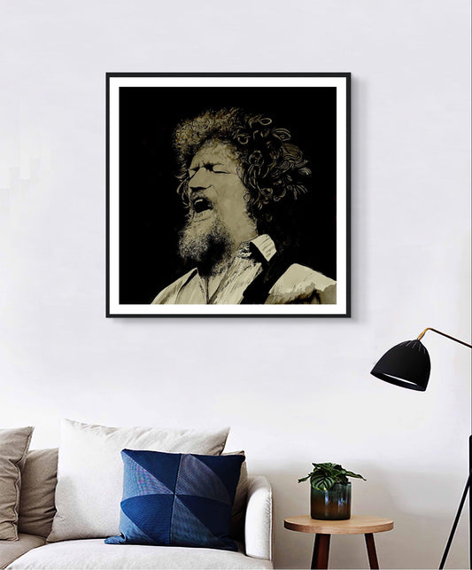 Luke Kelly portrait framed print in a black frame above a white sofa with a floor lamp