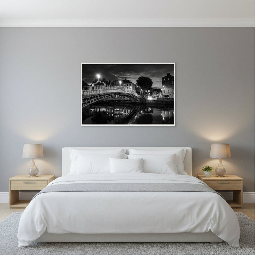 Contemporary bedroom, soft grey walls, king bed with white linens, large 60x90 cm Ha’penny Bridge black and white print in white frame above the headboard, warm bedside lamps, calm and elegant atmosphere, realistic interior wall art