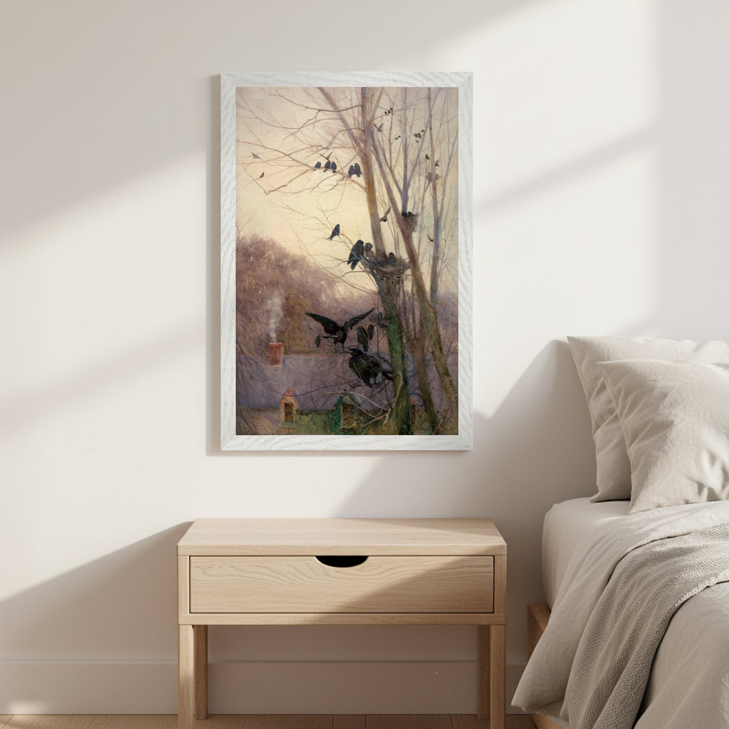 Shades of Evening by Mildred Anne Butler, 30x45 cm Collector’s Edition in white wooden frame mounted on a warm off-white wall in a calm bedroom interior. Linen bedding, light wood bedside table, warm morning light, soft shadows. Artwork shows an Irish cottage scene with rooks in leafless trees at dusk. Premium, serene, airy aesthetic.