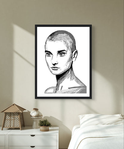 Sinéad O'Connor black and white line portrait print in a black frame above a white bedside table