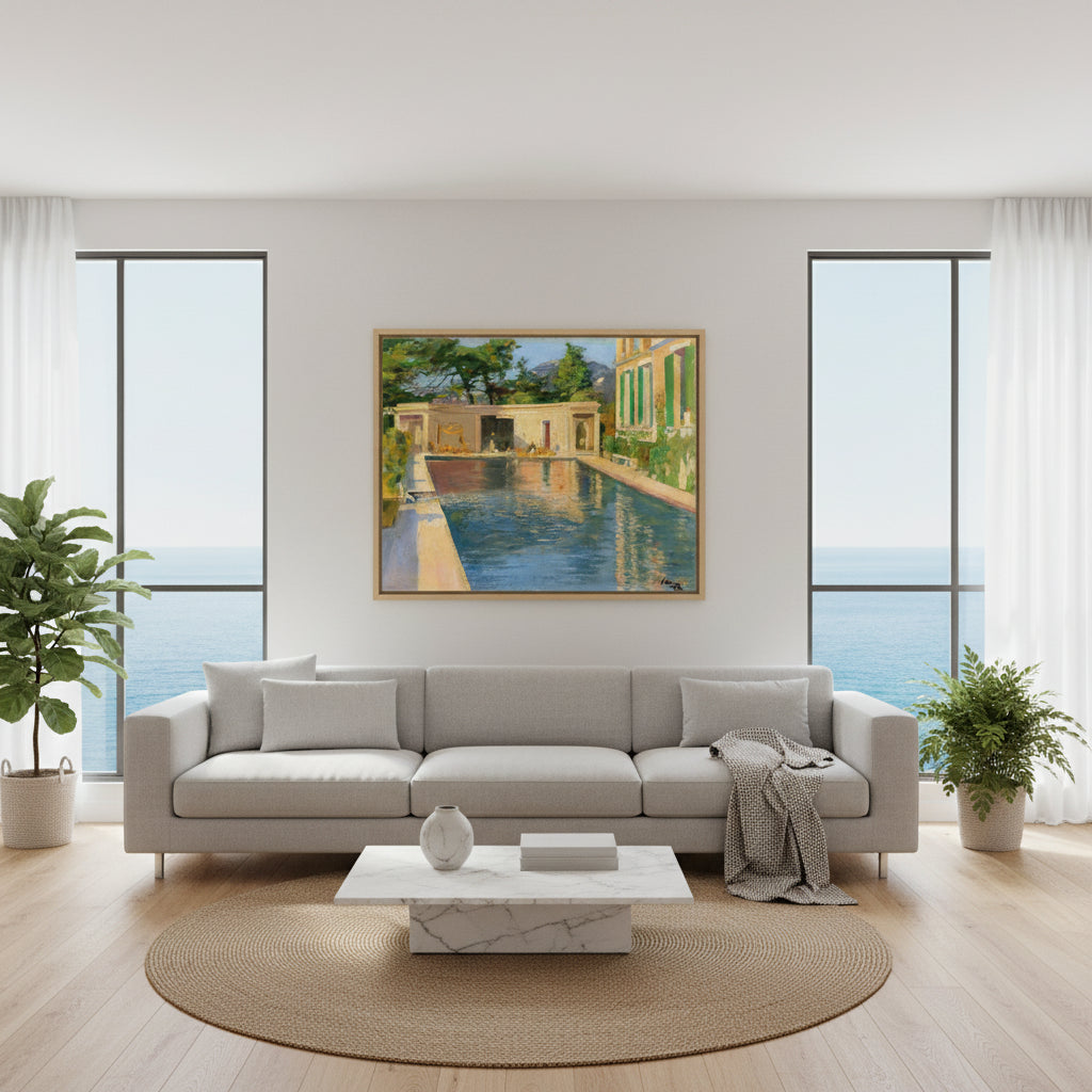 Swimming Pool, Southern France – Sir John Lavery Collector’s Print. Collector’s Edition framed “Swimming Pool, Southern France” above a modern sofa in a bright coastal apartment with big windows, sea-light ambience, minimalist decor.