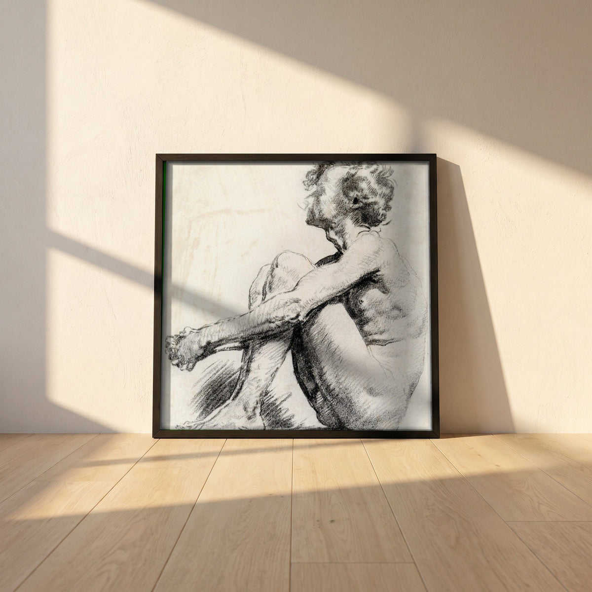A Seated Male Figure by Sarah Purser framed print in a black frame leaning against a white plaster wall on oak floorboards in morning light