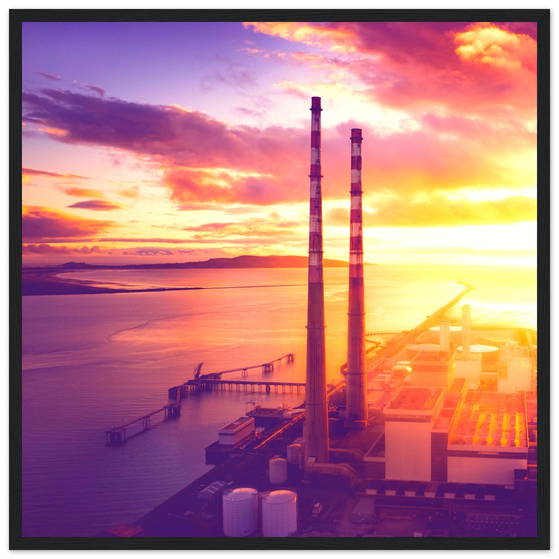 A framed print of Dublin's industrial landscape, featuring the iconic Poolbeg Towers and Lighthouse at sunrise. This aerial view captures the blend of industrial structures with a serene, sunlit horizon, showcasing the harmony between technology and nature. Perfect for admirers of drone photography, industrial architecture, and Ireland's coastal beauty.