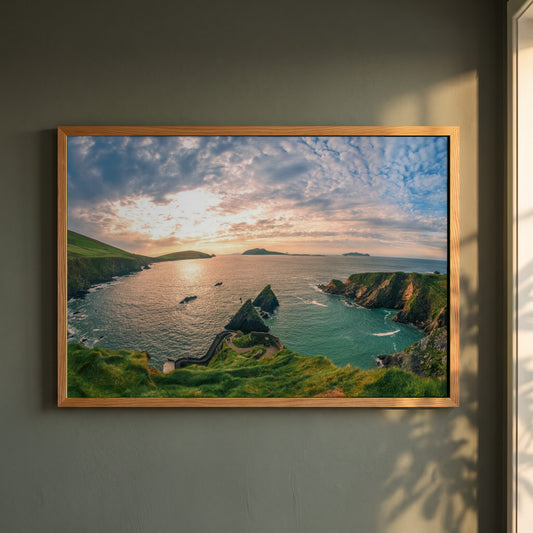 Dingle Peninsula framed print in a natural oak frame on a dark green wall beside a window, dappled plant shadow