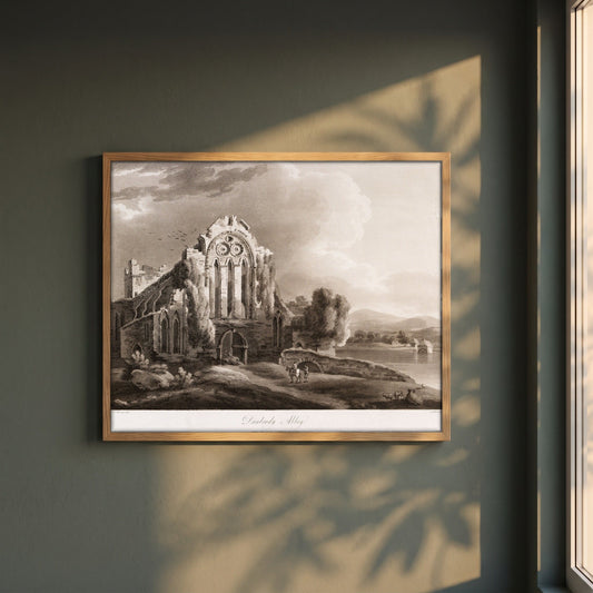 Dunbrody Abbey by Thomas Sautelle Roberts Art Print framed print in a natural oak frame on a dark green wall beside a window, dappled plant shadow