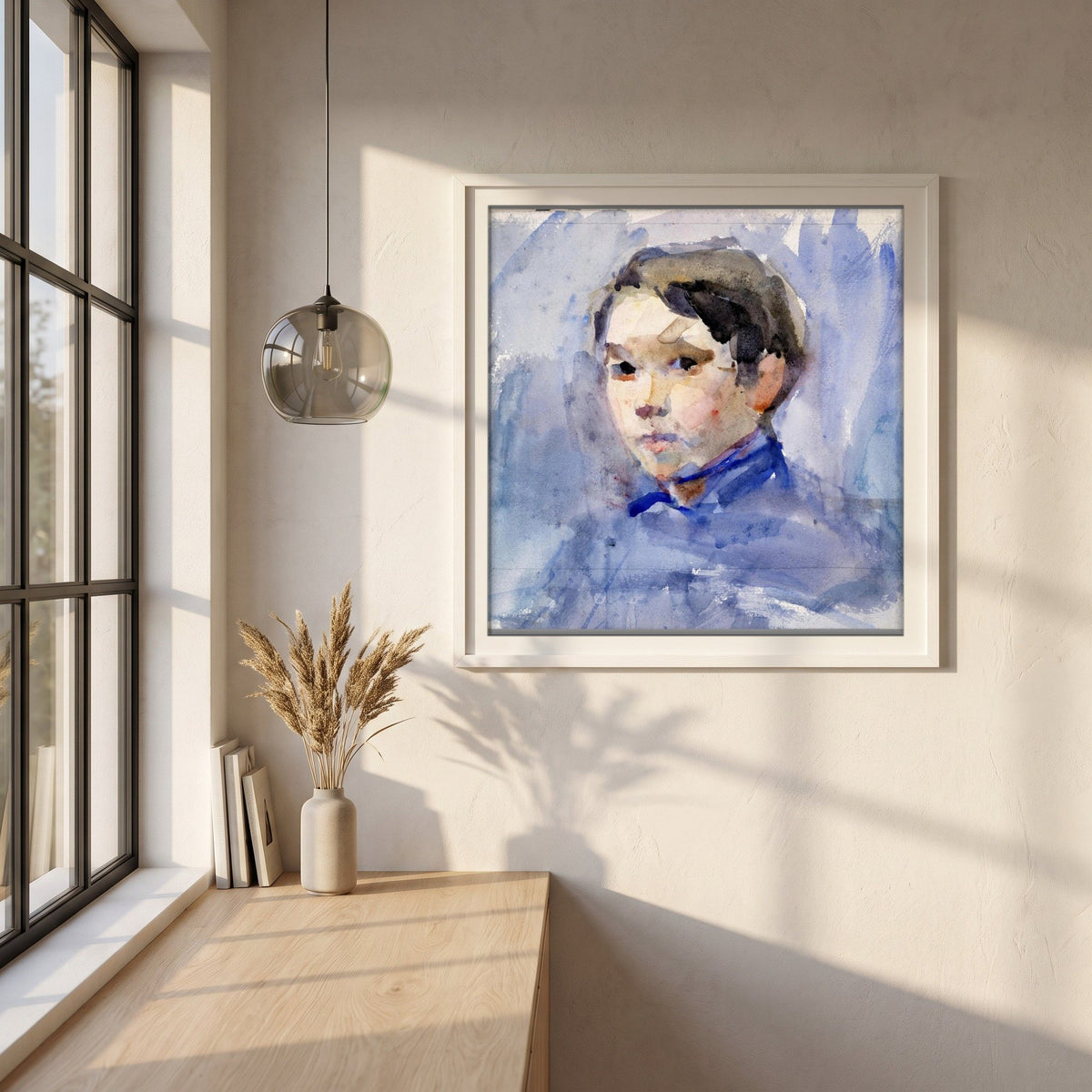 Head of a Young Boy by Clare Marsh framed print in a white frame on a plaster wall above an oak worktop in a bright Scandinavian kitchen