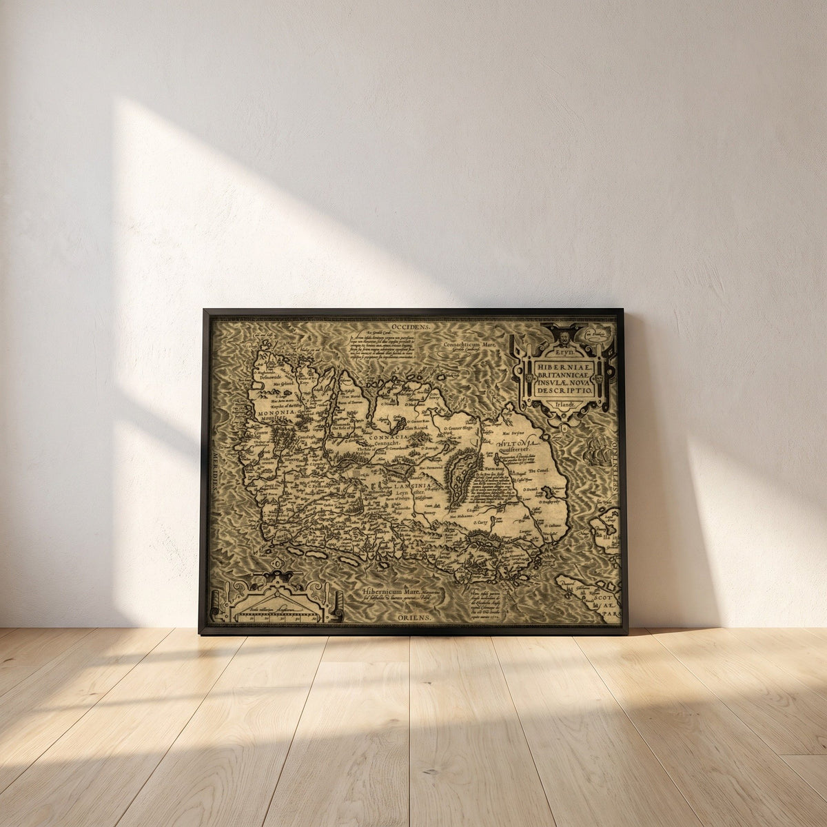 Hiberniae, Britannicae Insvlae nova descripto Ireland map framed print in a black frame leaning against a white plaster wall on oak floorboards in morning light