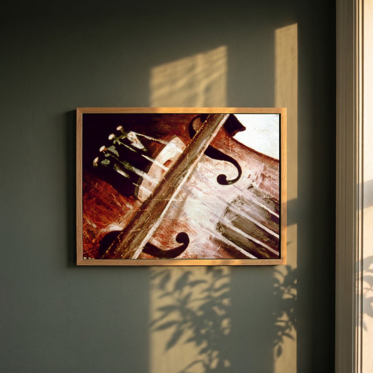 Irish Fiddle & Bow framed print in a natural oak frame on a dark green wall beside a window, dappled plant shadow