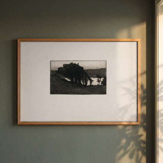 Landscape with Dark Trees and a River framed print in a natural oak frame on a dark green wall beside a window, dappled plant shadow