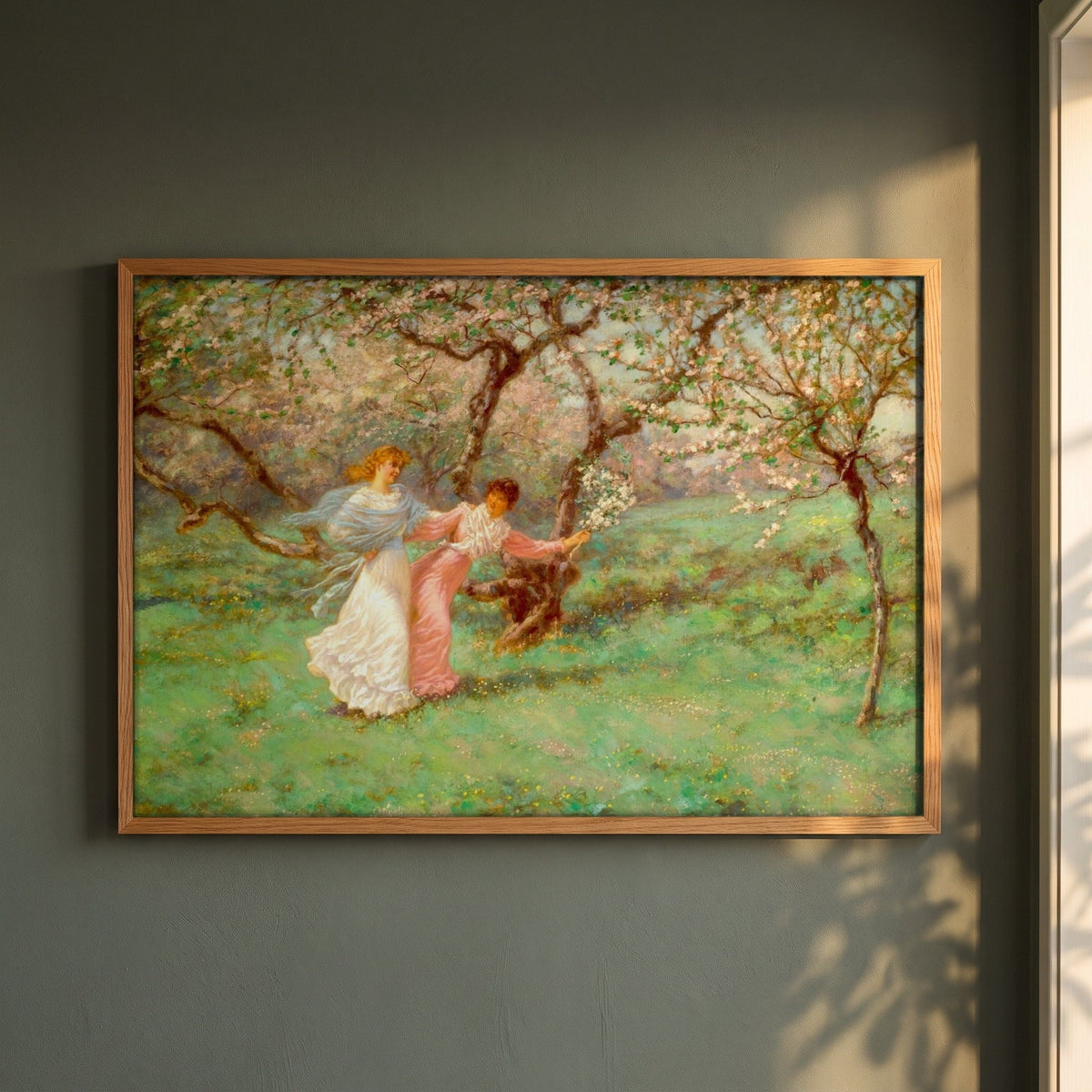 The Flowers of May by William John Hennessy framed print in a natural oak frame on a dark green wall beside a window, dappled plant shadow